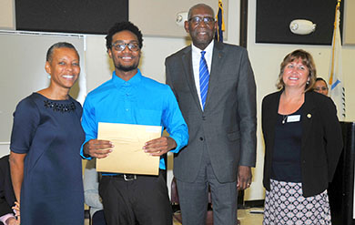 A student Receives his Award from President David Hall and Provost Camille Mc Kayle